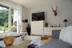 ein Wohnzimmer mit einem Sofa und einem TV in der Unterkunft Exklusive Villa am Wald mit Garten, Waldzugang und Sauna in Solingen