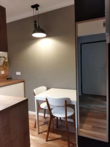 een keuken met een tafel en twee stoelen en een licht bij 2LKT studio apartman in Zagreb