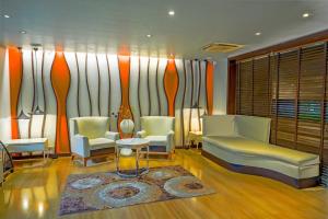 a living room with two chairs and a couch at Citrus Hotel Lonavala in Lonavala