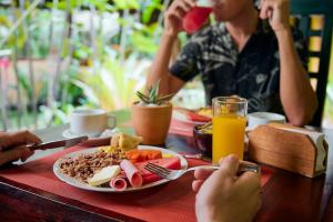 a person sitting at a table with a plate of food at Shawandha Lodge in Puerto Viejo