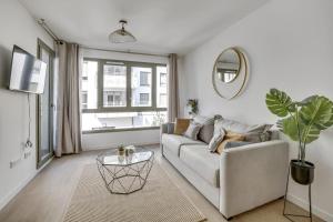sala de estar con sofá y mesa en Superbe appartement avec balcon et parking proche Paris, en Saint-Denis
