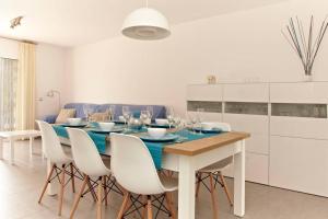 comedor con mesa azul y armarios blancos en Homing Cambrils 23, en Cambrils