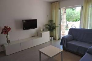 a living room with a blue couch and a tv at Homing Cambrils 23 in Cambrils