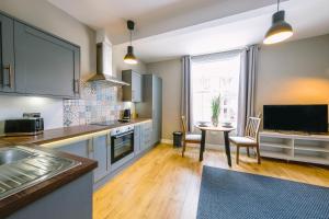 a kitchen with a table and a tv in it at Old Market Apartments in Bristol