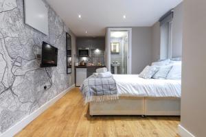 a bedroom with a bed and a tv on a wall at Old Market Apartments in Bristol