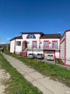a white and red house with a fence in front of it at Kalina in Chernivtsi