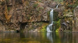 ein Wasserfall an der Seite einer felsigen Klippe in der Unterkunft LA SERRANITA - Frente al Rio in Río Ceballos