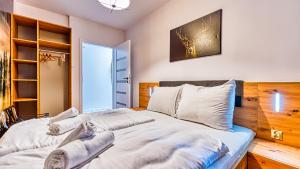 una camera da letto con un grande letto con cuscini bianchi di Apartament Przy Wyciągu 1 - 5D Apartamenty a Świeradów-Zdrój