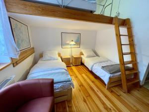 a bedroom with two bunk beds and a chair at Jasionowy Gaj in Jasionowo