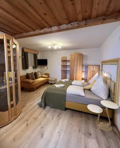 a bedroom with a large bed and a living room at Gästehaus Biobauernhof Mandl in Murau