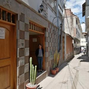 Una donna in piedi sulla porta di un palazzo di Dreams House Cusco a Cuzco