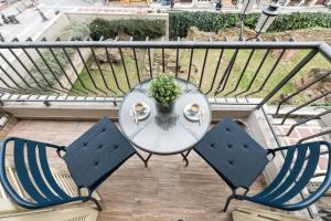 a glass table and two chairs on a balcony at Porto Sea View Apartments - Gounari in Thessaloniki