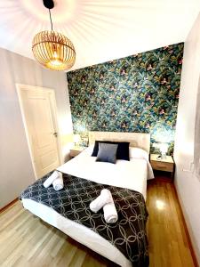 a bedroom with a bed and a floral wall at SeaHomes Vacations, FENALS BEACH&CHIC, pk, top apartment full equipped in Lloret de Mar
