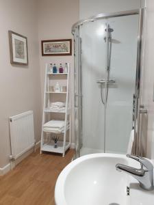 La salle de bains est pourvue d'une douche et d'un lavabo blanc. dans l'établissement The Clarendon Country Pub with rooms, à Grassington