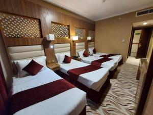 a group of four beds in a hotel room at Al Andalus Palace 3 in Al Madinah