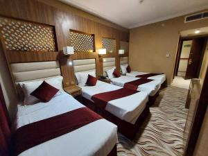 a group of four beds in a hotel room at Al Andalus Palace 3 in Medina