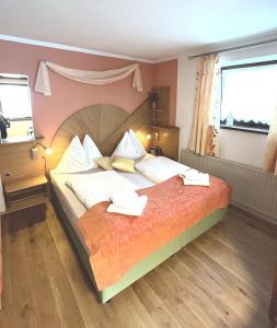 a bedroom with a large bed with two pillows at Gästehaus Biobauernhof Mandl in Murau