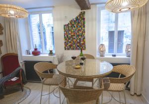a dining room with a table and chairs and windows at L'Escapade in Rouen