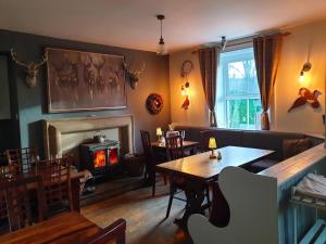 a dining room with a table and a fireplace at The Clarendon Country Pub with rooms in Grassington