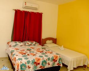 a bedroom with a bed and a red curtain at Pousada aconcheg'us in Jijoca de Jericoacoara