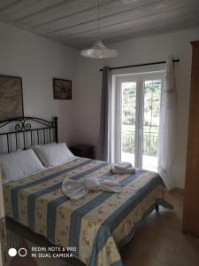 a bedroom with a bed and a window at Villa Nikos in Ágios Stéfanos