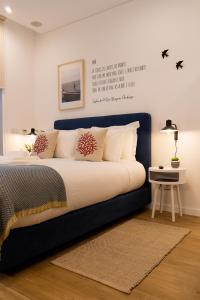 a bed with a blue headboard in a bedroom at Oliva Teles 53 - Sophia Terrace in Arcozelo