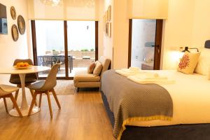 ArcozeloにあるOliva Teles 53 - Sophia Terraceのベッド、テーブル、椅子が備わるホテルルームです。