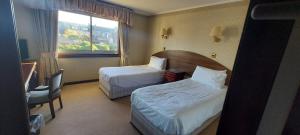a hotel room with two beds and a window at Gordon Arms Hotel in Fochabers
