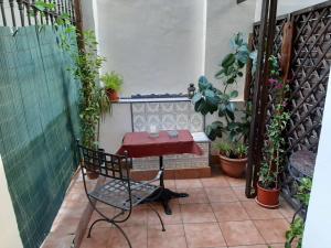 a table and chair on a patio with plants at Casa Consell Bailen, Guest House in Barcelona