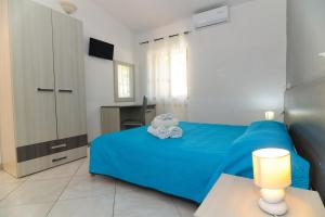 a bedroom with a blue bed with towels on it at B&B del Sole Tropea in Tropea