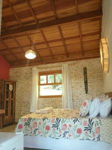una camera con un letto in una stanza con una finestra di Nas Nuvens Hospedaria a Monte Verde