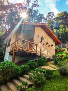uma casa com um raio de luz a brilhar nela em Nas Nuvens Hospedaria em Monte Verde