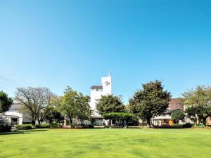 a large grass field with a clock tower in the background at Fujieda Park Inn Hotel in Fujieda