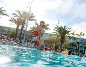 a man standing in a swimming pool at a resort at Universal's Cabana Bay Beach Resort in Orlando