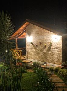 a brick building with two faces on it at night at Nas Nuvens Hospedaria in Monte Verde