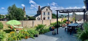 eine Terrasse mit einem Tisch und Stühlen sowie ein Haus in der Unterkunft Ty Ana in Ploubazlanec