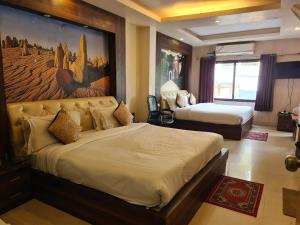 a hotel room with two beds and a painting on the wall at Hotel Rajpur Heights in Dehradun