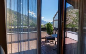 a balcony with a view of the mountains through a window at Relais Bayard in Susten