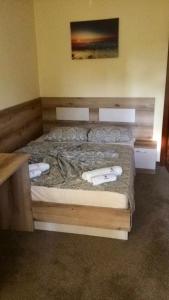 una camera da letto con un letto con due asciugamani bianchi di Sunny Paradise Family Hotel a Kiten