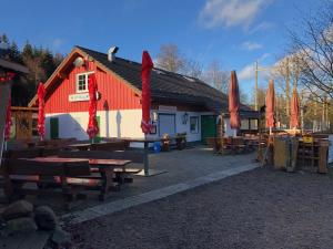 un edificio rosso e bianco con tavoli da picnic e ombrelloni di Ferienhaus Küstelnest a Medebach