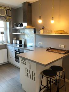 a kitchen with a counter and two stools in it at Seepark Seepark 3f in Heiligenhafen