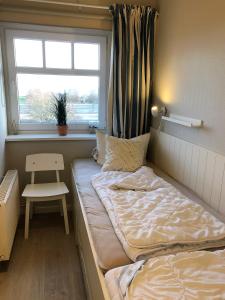 Un dormitorio pequeño con una cama y una ventana. en Seepark Seepark 3f, en Heiligenhafen