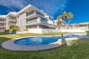 una casa grande con piscina frente a una casa en Ático Saona en Aduanas