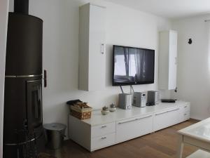 a living room with a television on a white dresser at Ferienwohnung Staudacher in Rohrdorf