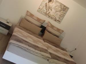 1 cama con almohadas y una foto en la pared en Ferienwohnung Staudacher, en Rohrdorf