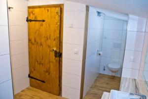 bagno con porta in legno e servizi igienici. di Ruphäusl a Ramsau am Dachstein