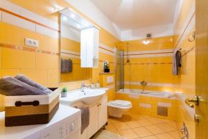 bagno giallo con lavandino e servizi igienici di Apartments Dea Caeli a Vela Luka (Vallegrande)