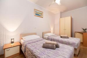 a bedroom with two beds and a night stand at Apartments Dea Caeli in Vela Luka