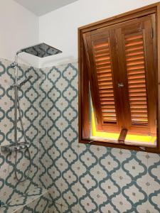 a bathroom with a window and a tiled floor at Villa GRENADINE - CLIM & TERRASSE- Face MER Vue panoramique, les pieds dans l'eau - OFFRE SPECIALE - LES SAINTES in Terre-de-Haut