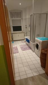 a bathroom with a washing machine and a tiled floor at Halle Saale 402 in Ammendorf